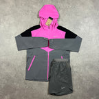 Nike Windrunner Playful Pink Shorts Set – pink, black and grey colour-block hooded jacket with matching grey Nike shorts laid flat with tag attached