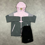 Nike Windrunner Pink Foam Shorts Set – pink and grey colour-block hooded jacket with black Nike shorts laid flat with tag attached