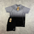 ASICS Seamless T-Shirt & Core Shorts Black – grey-to-black gradient seamless t-shirt with ASICS chest logo and perforated panel detailing, paired with black core shorts with white ASICS logo, flat lay on concrete surface with tags attached