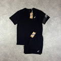 ASICS Icon T-Shirt & Core Shorts Set Black – black crew-neck t-shirt with white ASICS chest logo and  sleeve panel logo, paired with black core shorts with ASICS logo, flat lay on concrete surface with tags attached